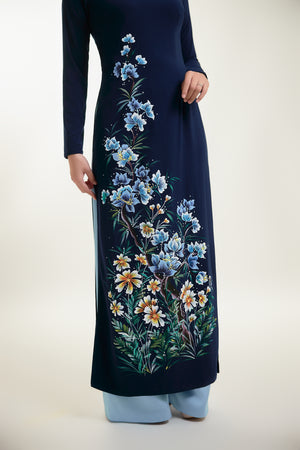 Close-up of hand-painted floral design on dark blue silk Ao Dai.