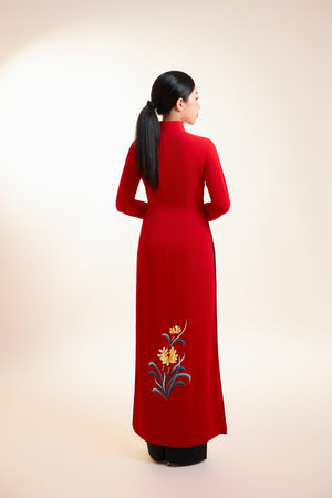 Back view of red silk Ao Dai with chrysanthemum embroidery near the hem, showcasing its elegant simplicity.