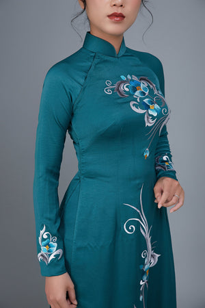 Women's ao dai dress Vietnamese traditional long dress. High quality teal colored fabric with embroidered, floral motif.