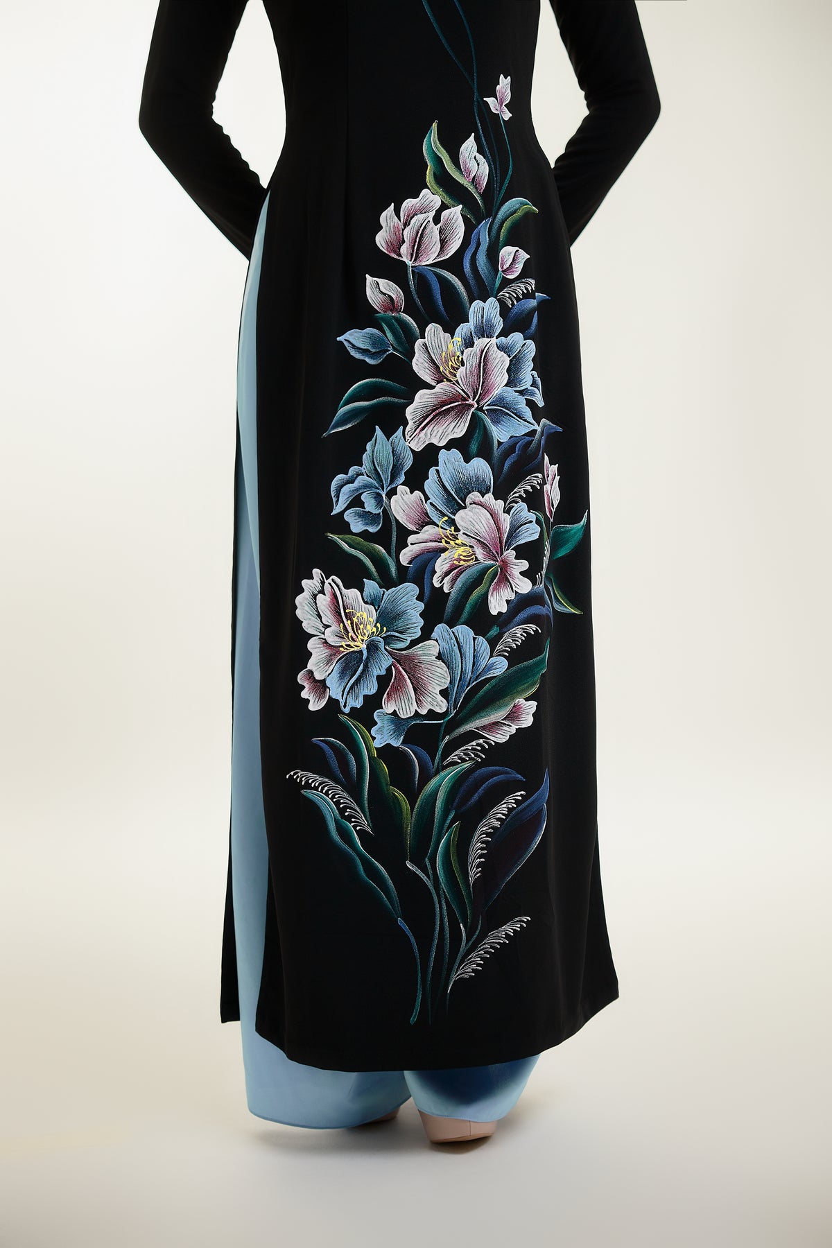 Close-up of intricate floral hand-painted design on black silk Ao Dai.