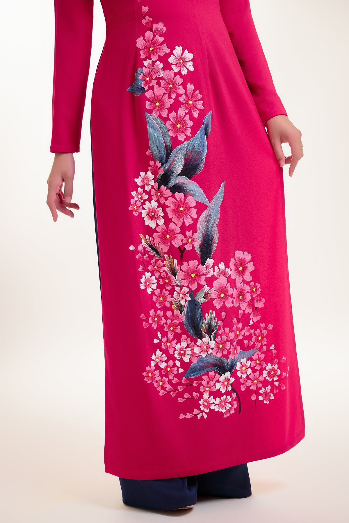 Close-up of hand-painted floral details on fuchsia pink Ao Dai silk.