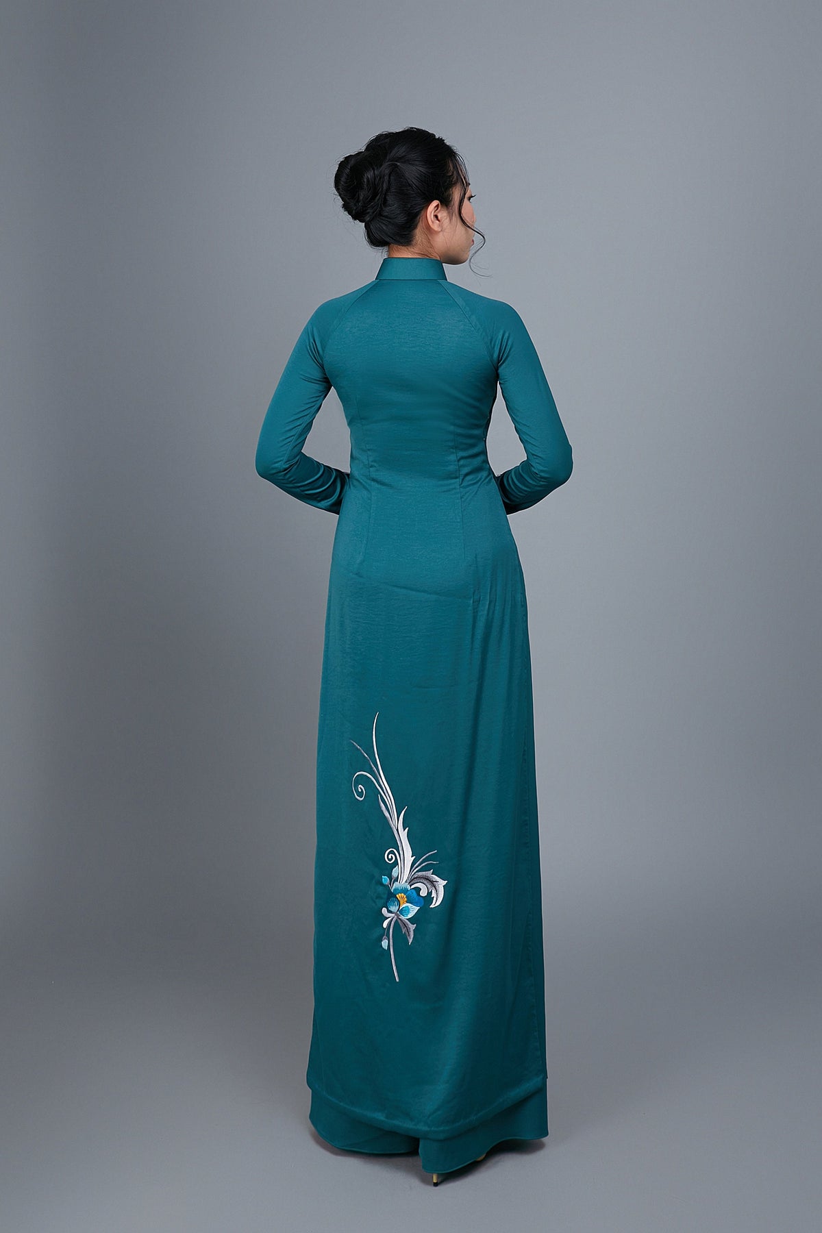 Women's ao dai dress Vietnamese traditional long dress. High quality teal colored fabric with embroidered, floral motif.